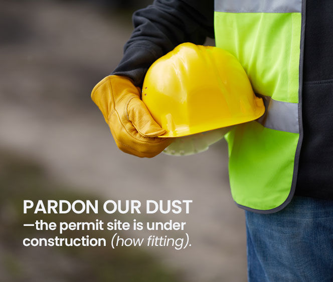 worker wearing vest holding yellow hardhat