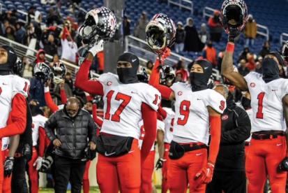 group of individuals dressed in football uniforms celebrate