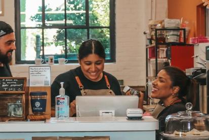 Three people working behind the counter at Dahlia Coffee Co. 