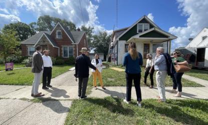 people standing in front of house being remodeled
