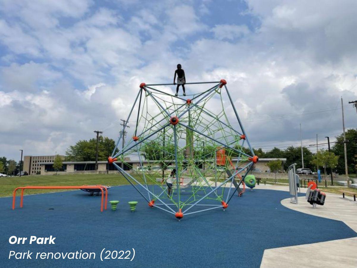 Orr Park renovation showing a large geometric rope climbing structure with a kid climbing on it.