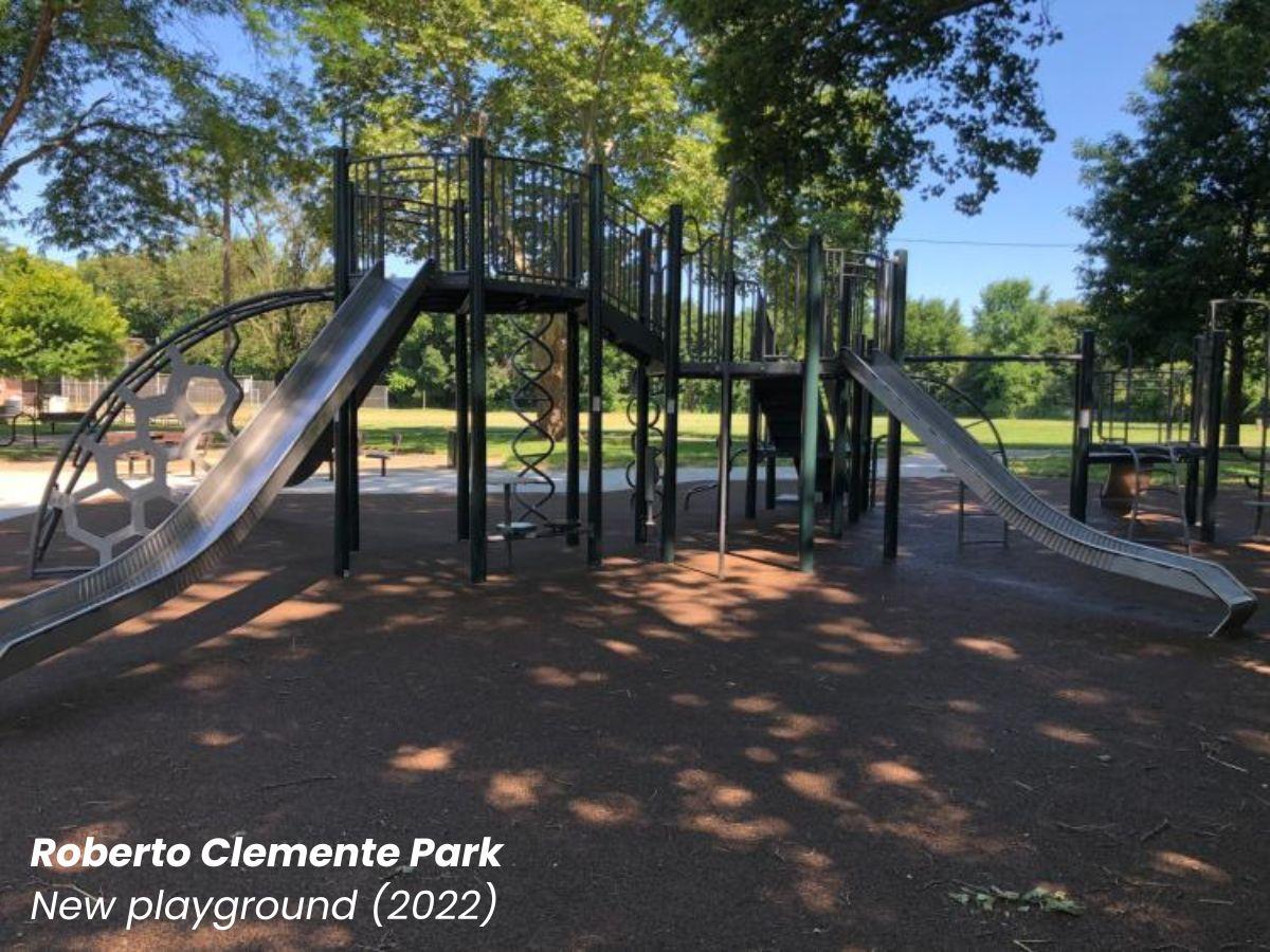 Roberto Clemente Park new playground that is silver and green covered by tree canopy.