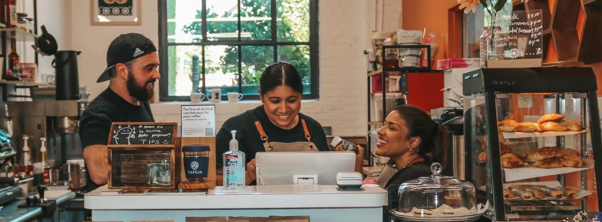 Three people working behind the counter at Dahlia Coffee Co. 