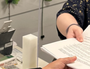 person handing paperwork to another person