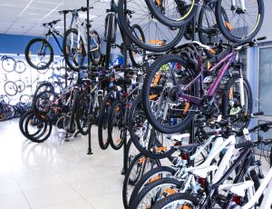 Bike shop with different brands & types of bicycles both on the ground and hanging from the ceiling