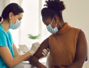 female health care provider vaccinating a female patient